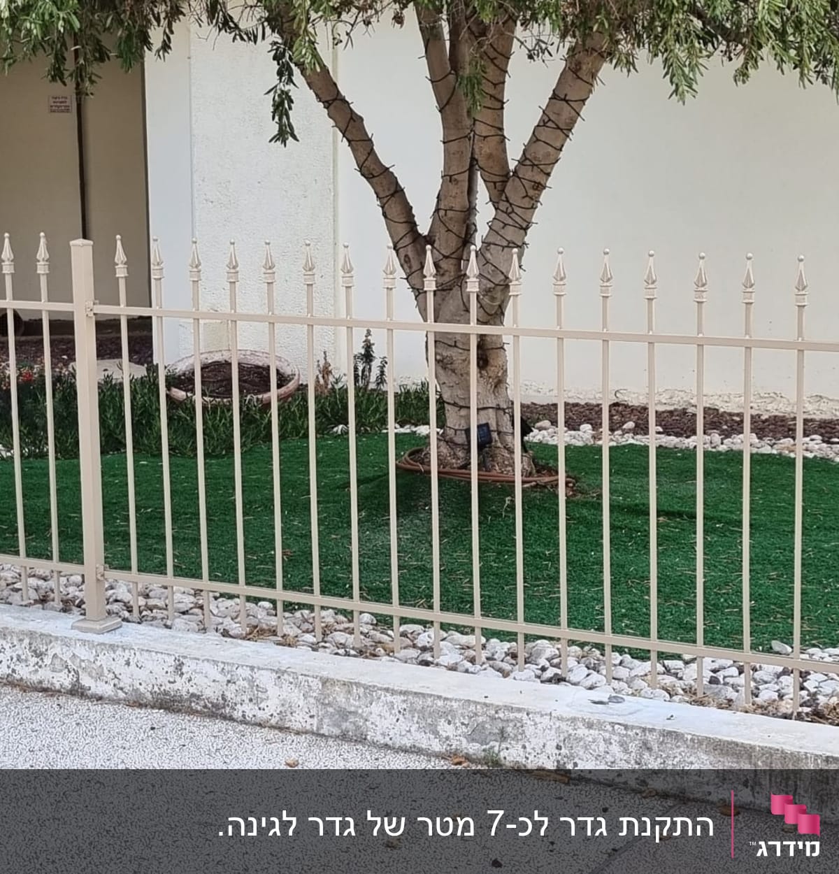 גדר מתכתית סביב עץ ודשא מלאכותי